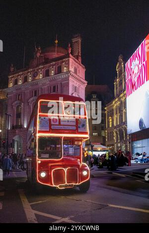 Ein Routemaster Bus bei Nacht am Piccadilly Circus, London Stockfoto