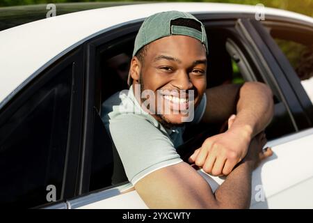 Die besten Freunde, die zusammen mit dem Auto reisen, durch die Fenster schauen, die Kamera anlächeln und im Sommer eine lustige Reise Unternehmen Stockfoto