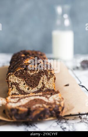 Ein frisch gebackener, zuckerfreier Bananen- und Schokoladenmarmorlab aus Vollweizen- und Dinkelmehl sitzt auf einer mit Pergament gefütterten Oberfläche Stockfoto