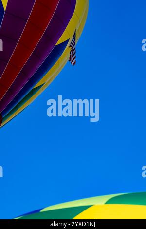 Leuchtende Luftballons aller Formen und Farben schweben in den klaren blauen Himmel und erfüllen die Luft bei einem klaren Ballonfest im Herbst mit Spannung. Die sc Stockfoto