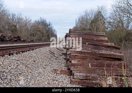 Stapel alter Eisenbahnverbindungen neben Gleisen Stockfoto