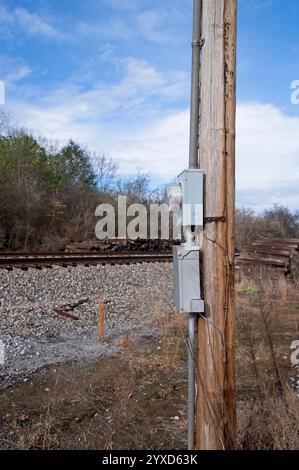 Elektrischer Zähler am Strommast neben den Gleisen Stockfoto