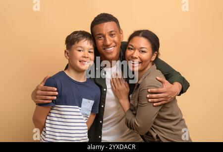 Familie mit drei Personen, die Liebe und Freude in einer warmen, hellen Umgebung teilen Stockfoto