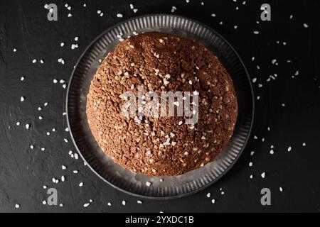 Italienischer Weihnachtskuchen Panettone, weiches traditionelles süßes Brot mit Nüssen, Rosinen und Schokolade auf festlichem schwarzem Hintergrund Stockfoto