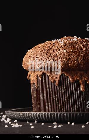 Italienischer Weihnachtskuchen Panettone, weiches traditionelles süßes Brot mit Nüssen, Rosinen und Schokolade auf festlichem schwarzem Hintergrund Stockfoto