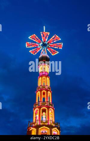 Helle große hölzerne Weihnachtspyramide während des Adventsmarktes vor dem Nachthimmel Stockfoto