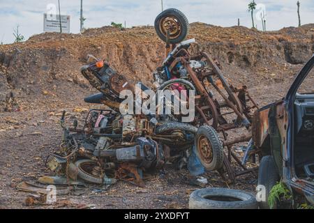 Balikpapan, Indonesien - 19. November 2024. Eine Sammlung alter, rostiger Motorräder, die auf einem Schrottplatz zusammengestapelt sind. Stockfoto