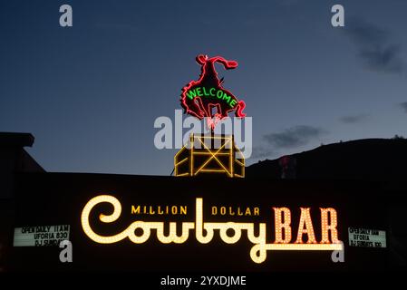 Vintage-Neonschild für die ikonische Million Dollar Cowboy Bar mit einem Cowboy, der auf einem Bockpferd reitet. Fotografiert zur blauen Stunde in Jackson, Wyoming. Stockfoto