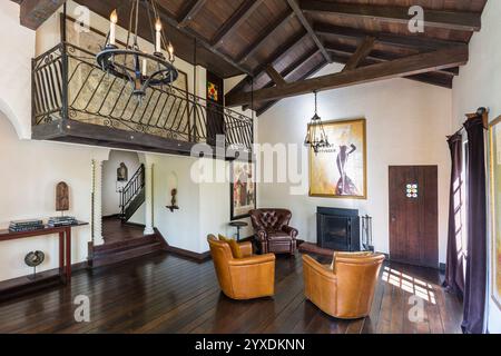 Elegantes Wohnzimmer eines Hauses im spanischen eklektischen Stil mit offener Decke aus Kathedralholz und schmiedeeisernem Balkon Stockfoto