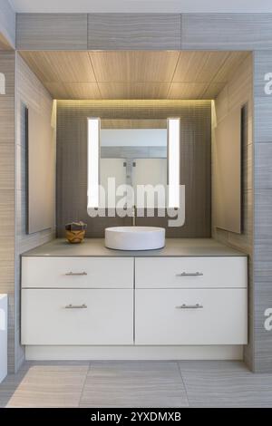 Moderner Kosmetikbereich im Bad zwischen zwei grauen gefliesten Wänden Stockfoto