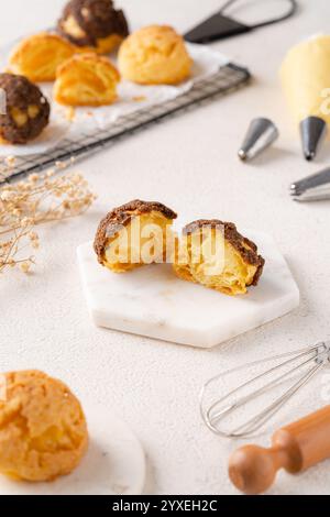 Choux-Gebäck ist ein zarter Teig, der in vielen Backwaren verwendet wird. Es enthält nur Butter, Wasser, Mehl und Eier. Choux-Gebäck wird manchmal gefüllt Stockfoto