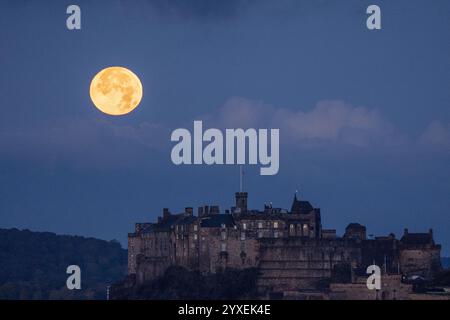 PA REVIEW OF THE YEAR 2024 Aktenfoto vom 17.10.24: Der volle Oktobermond, bekannt als der Jäger, untergeht hinter Edinburgh Castle. Ausgabedatum: Montag, 16. Dezember 2024. Stockfoto