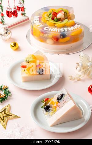 Hausgemachter Fruchtpudding mit Zutaten aus Erdbeeren, Trauben, Orange, Longan, Kiwi und Pfirsich, die mit Weihnachtsdekorationen dekoriert sind Stockfoto