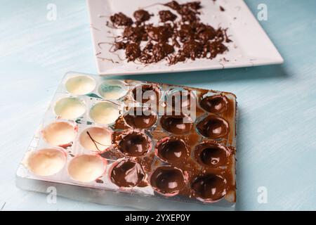 Die Hände der Konditorin füllen sich mit Schokolade, Formen für die Herstellung von hausgemachten Pralinen mit einem Kochbeutel. Hochwertige Fotos Stockfoto