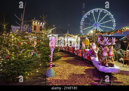 London, Großbritannien. Dezember 2024. Kinder und Familien genießen eine Fahrt in einem festlichen Miniaturzug. Cranger Weihnachtszauber ist einer der größten mobilen Weihnachtsparks in Europa und bietet einen traditionellen deutschen Weihnachtsmarkt mit Ständen, eine Vergnügungsmesse mit Fahrgeschäften, eine Eislaufbahn, Lebensmittel- und Getränkemärkte, Eisstockschießen, kostenlose Kindershows, Weihnachtsfiguren und einen Santa-Schlitten mit Rentieren, die über die Messe fliegen. Sie läuft bis Dezember 30. Quelle: Imageplotter/Alamy Live News Stockfoto