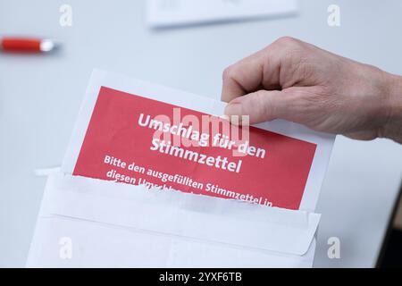 16. Dezember 2024, Sachsen, Dresden: Ein Stimmzettel wird aus einem Umschlag gezogen, da die Stimmen für die SPD-Mitgliederwahl im Herbert-Wehner-Haus gezählt werden. Die SPD in Sachsen bittet ihre Mitglieder, über den Koalitionsvertrag mit der CDU abzustimmen. Foto: Sebastian Kahnert/dpa Stockfoto