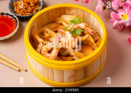 Garnelenknödel im Bambus-Dampfkorb. Dimsum ist eine große Auswahl an kleinen Gerichten, die Kantonesen traditionell in Restaurants zum Frühstück genießen Stockfoto