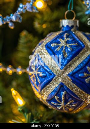 Eine blau-goldene Kugel, die einen Weihnachtsbaum ziert Stockfoto