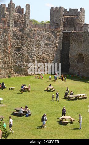 Touristen, die sich an einem Sommertag in den Hügeln des mittelalterlichen Framlingham Castle in Suffolk, England, Großbritannien entspannen Stockfoto