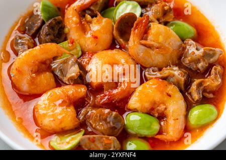 Chili Garnelen oder Sambal Udang mit Petai oder pete serviert auf weißem Teller Stockfoto