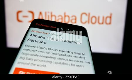 In dieser Abbildung ist ein Mobiltelefon mit der Website des chinesischen Computerunternehmens Alibaba Cloud vor dem Geschäftslogo zu sehen. Stockfoto