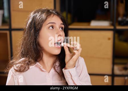 Die junge schöne Frau nimmt Pillen und Vitamine im Büro. Geschäftsfrau kümmert sich um Gesundheit und trinkt Medikamente. Stockfoto