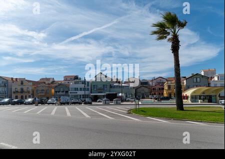 Costa Nova, Portugal - 11. September 2024 : Weiße und farbenfrohe Gebäude säumen eine Straße in einer Küstenstadt während des Tages Stockfoto