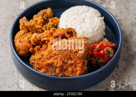 Ayam Geprek ist ein indonesisches Essen knuspriges gebratenes Huhn mit heißer und würziger Sambal Chili Sauce. Stockfoto