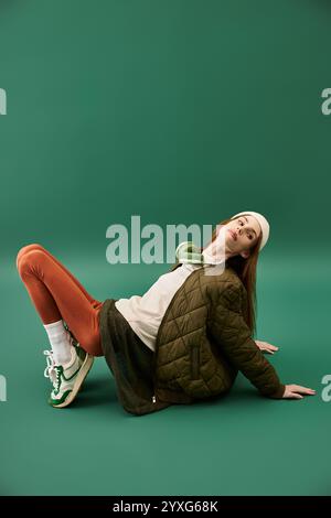 Eine junge Frau sitzt auf dem Boden und vermittelt Gefühle von Kampf und Schönheit in einem Studio. Stockfoto