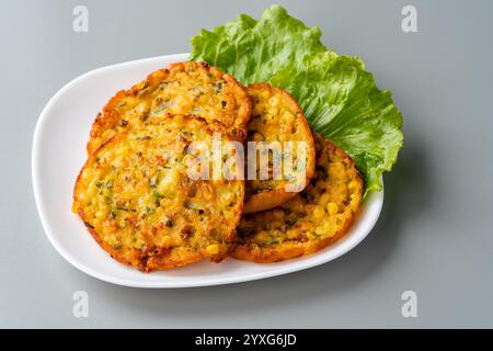 Perkedel jagung oder Bakwan jagung ist ein frittiertes Gericht aus Süßmais, Ei, Mehl, Frühlingszwiebeln, Pfeffer und Salz Stockfoto