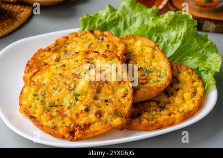 Perkedel jagung oder Bakwan jagung ist ein frittiertes Gericht aus Süßmais, Ei, Mehl, Frühlingszwiebeln, Pfeffer und Salz Stockfoto