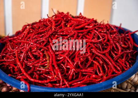 Haufen frischer Chilis und reifer roter Chilis in Körben zum Verkauf auf dem Gemüsemarkt Stockfoto