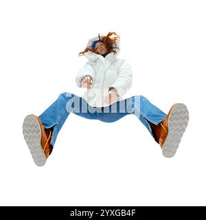 Bild von unten: Junge Frau in weißer, geschwollener Jacke und Jeans posiert in dynamischer Pose in der Luft. Modern, modisch und jugendlich Stockfoto