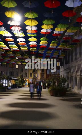 Wunderschöne Altstadt mit beleuchteten bunten Hängeschirmen mit Schatten auf der Stadtstraße bei Nacht in Olten, Kanton Solothurn, Schweiz, Europa Stockfoto