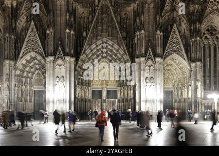 Nachtansicht der Domfassade mit vorbeiziehenden Menschen im Vordergrund, Domplatte, Roncalliplatz, Köln, Nordrhein-Westfalen, Deutschland, Euro Stockfoto