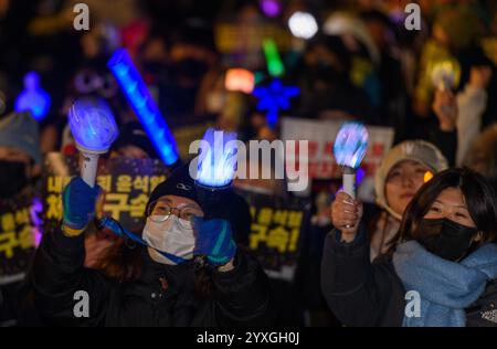 Seoul, Südkorea. Dezember 2024. Demonstranten winken K-POP-Lichtstäbe mit Plakaten mit der Aufschrift 'Verhaften des Aufklärungsbeamten Yoon Suk Yeol!' Während einer Kundgebung, die die Festnahme des angeklagten südkoreanischen Präsidenten Yoon Suk Yeol in der Innenstadt von Seoul forderte. Quelle: SOPA Images Limited/Alamy Live News Stockfoto