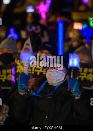 Seoul, Südkorea. Dezember 2024. Demonstranten winken K-POP-Lichtstäbe mit Plakaten mit der Aufschrift 'Verhaften des Aufklärungsbeamten Yoon Suk Yeol!' Während einer Kundgebung, die die Festnahme des angeklagten südkoreanischen Präsidenten Yoon Suk Yeol in der Innenstadt von Seoul forderte. Quelle: SOPA Images Limited/Alamy Live News Stockfoto