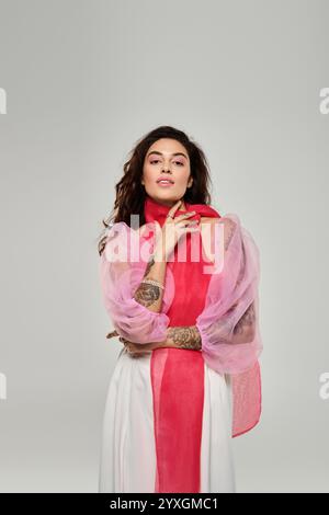 Die wunderschöne junge Frau zeigt einen einzigartigen modischen Stil mit farbenfroher Kleidung und selbstbewusster Pose. Stockfoto