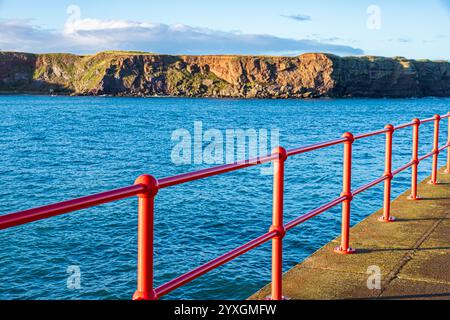 Glänzende neue rote Geländer am West Pier im Hafen von Eyemouth, Berwickshire, Scottish Borders, Schottland, Großbritannien Stockfoto