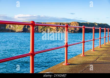 Glänzende neue rote Geländer am West Pier im Hafen von Eyemouth, Berwickshire, Scottish Borders, Schottland, Großbritannien Stockfoto