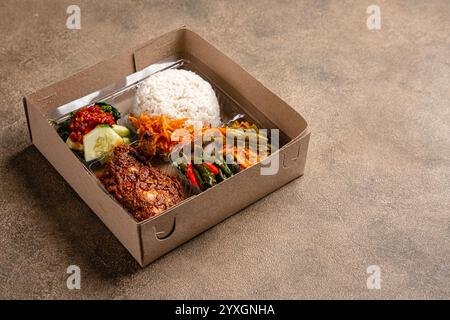 Auf Indonesisch wird er als Rice Box oder Nasi kotak mit Ayam Rendang bezeichnet. Wird in der Regel während Feierlichkeiten oder Verpflegungsverpackungen verteilt. Stockfoto