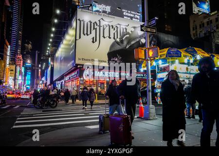 Besucher des Times Square in New York am Mittwoch, den 4. Dezember 2024, spazieren unter einer Werbung für den ÒNosferatuÓ-Film, einem Remake des Stummvampirfilms von 1922, der am Weihnachtstag in den USA veröffentlicht wird. (© Richard B. Levine) Stockfoto