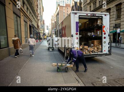 FedEx-Mitarbeiterin mit ihren Paketen in Chelsea in New York am Freitag, den 6. Dezember 2024. (© Richard B. Levine) Stockfoto