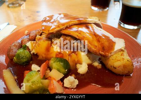Pub christmas Lunch mit truthahnschinken gefüllt Kartoffeln, Sprossen und Gemüse Teil einer weihnachtsarbeit in großbritannien Stockfoto