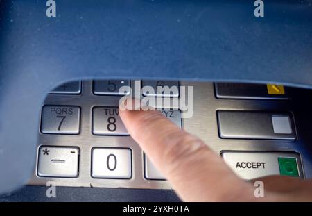 Nahansicht eines Fingers, der am Geldautomaten oder Geldautomaten die Zifferntasten drückt. Stockfoto