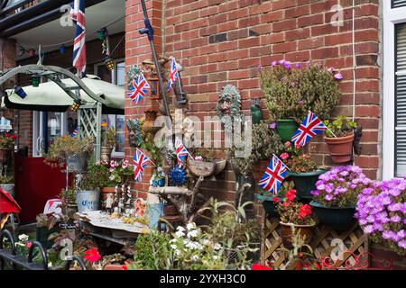Patriotische Gartenausstellung mit Union Jack Flaggen, Topfpflanzen und Ornamenten vor einem Haus in Hastings, England Stockfoto