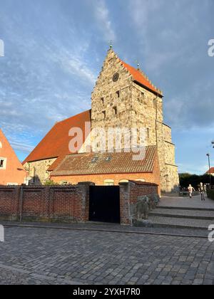 Kirche Sankt Nicolai in Simrishamn, Schweden, beleuchtet von der Sonne und mit bewölktem und blauem Himmel im Hintergrund. Foto im Sommer 2023. Stockfoto