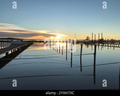 Sonnenuntergang spiegelt sich im Wasser auf einem kleinen Hafen in Västerås, Schweden. Foto im November 2022. Stockfoto