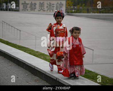 Kleine japanische Mädchen mit Geisha-Kostümen an der Außenseite des Kyoto City KYOCERA Kunstmuseums im Okazaki Park in Sakyō-ku Kyoto, Japan. Stockfoto