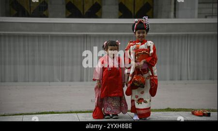 Kleine japanische Mädchen mit Geisha-Kostümen an der Außenseite des Kyoto City KYOCERA Kunstmuseums im Okazaki Park in Sakyō-ku Kyoto, Japan. Stockfoto